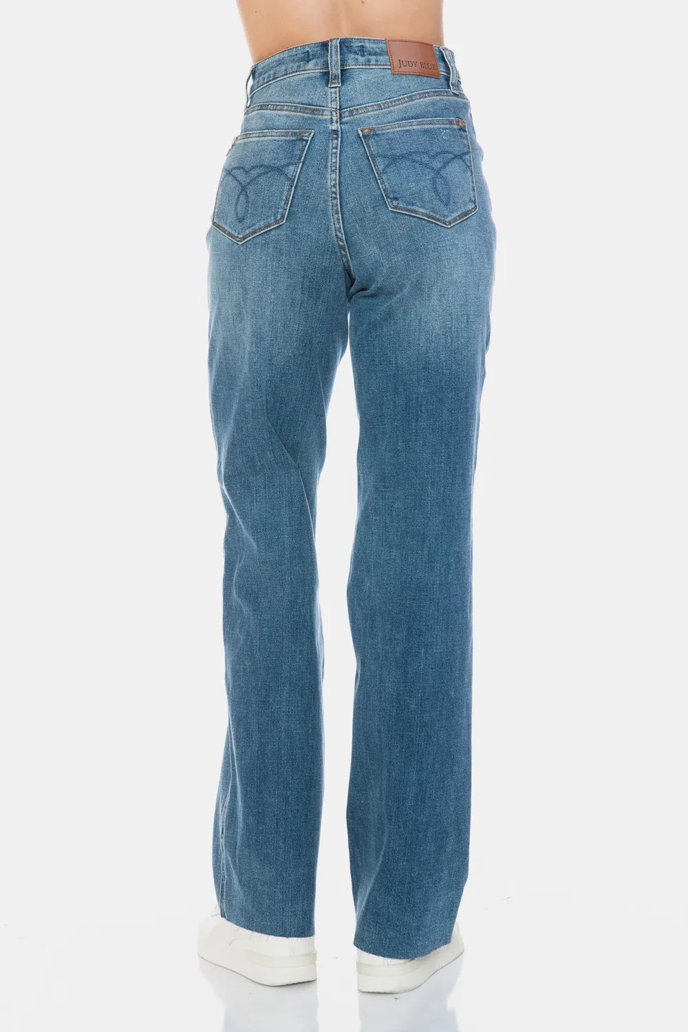 Medium-wash straight jeans back view, belt loops and raw hem