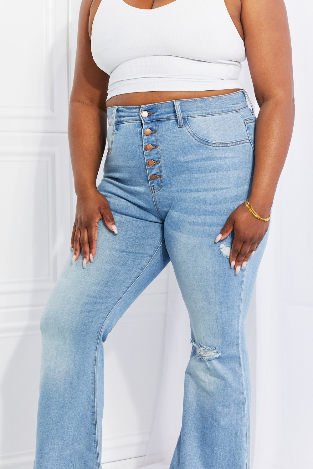 Light blue button-fly jeans with distressed thigh and knee rips, regular fit