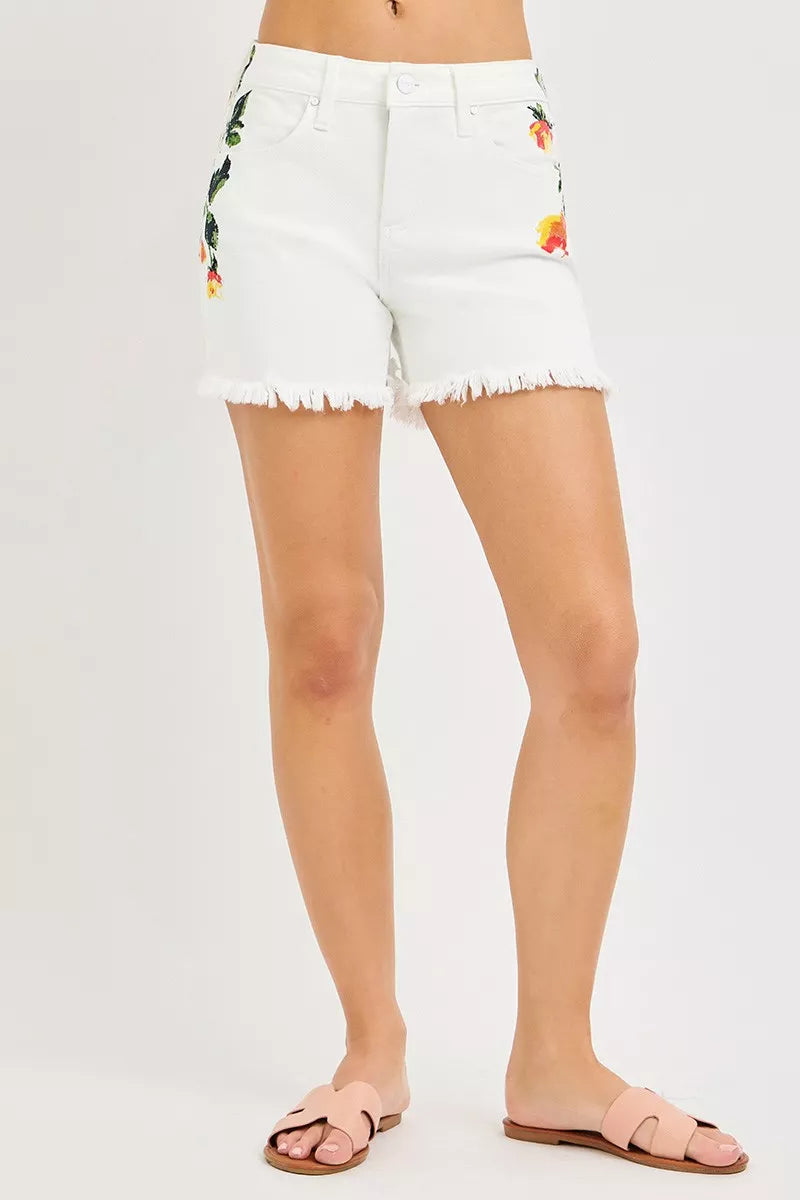 White floral-print denim shorts with frayed hem and front pockets