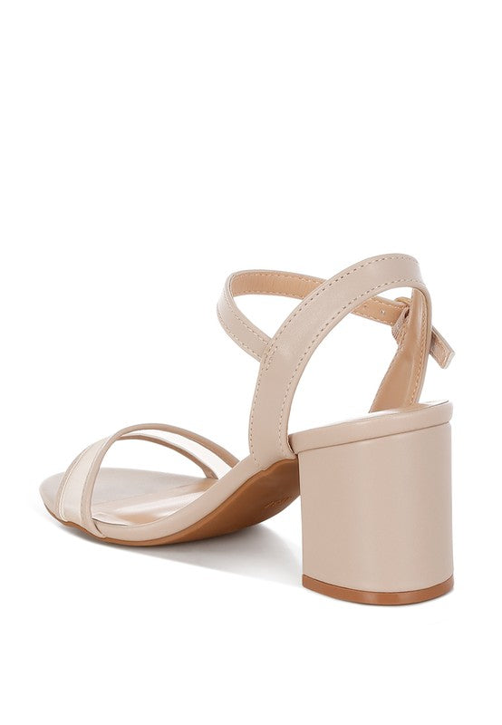 Beige block heel sandal angled view with pin buckle at ankle strap