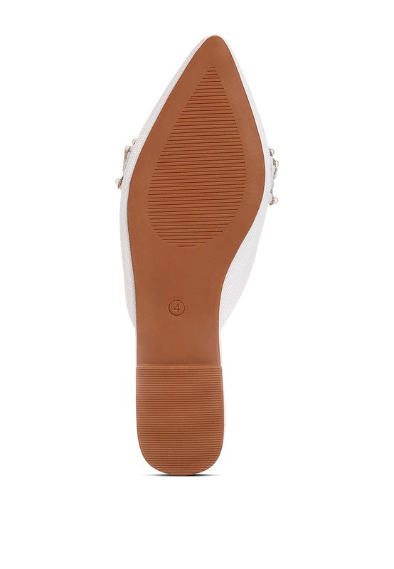 Underside sole of white mules with flat low heel and textured grip