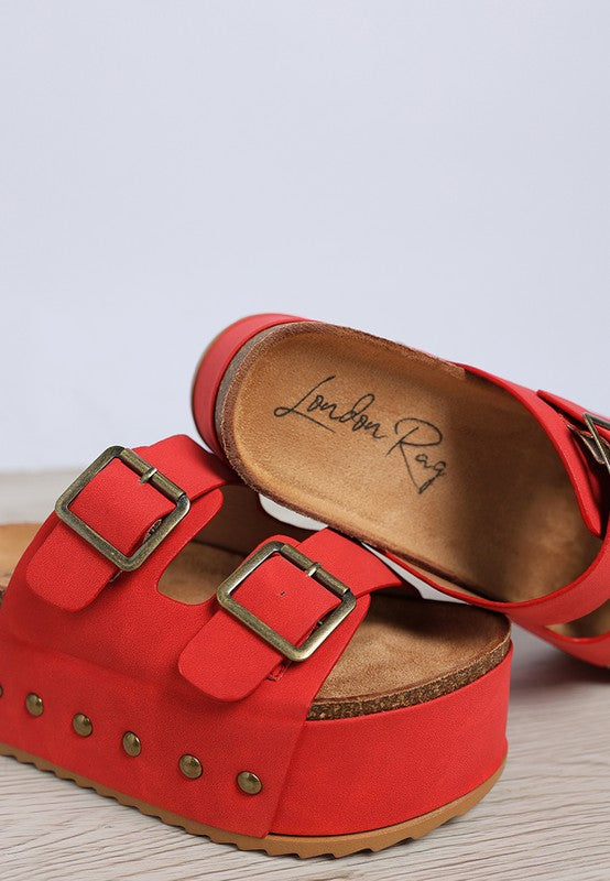 Red flatform slide sandals with two buckles and stud accents on the front band