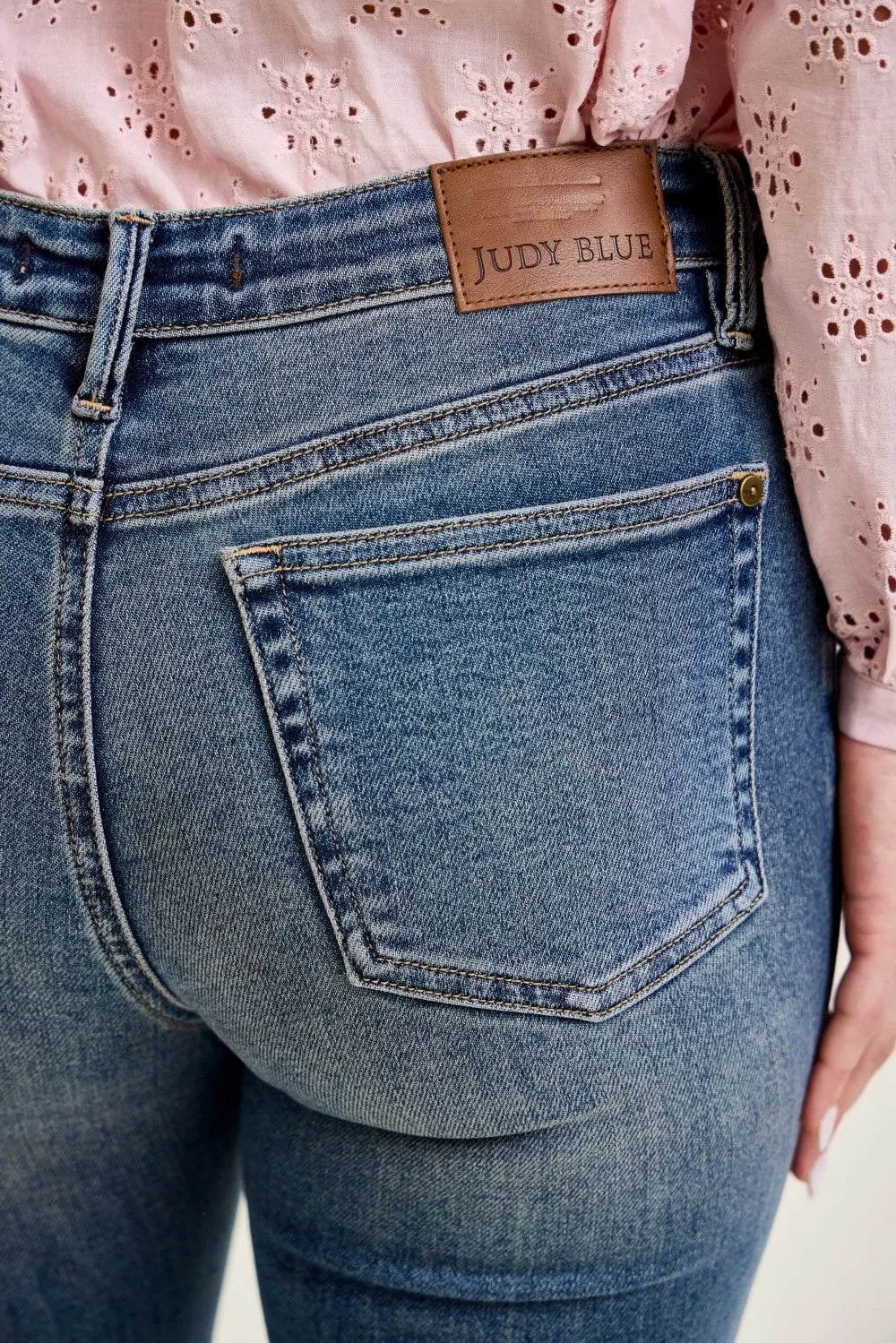 Front pocket flap on dark wash jeans with “Judy Blue” logo patch
