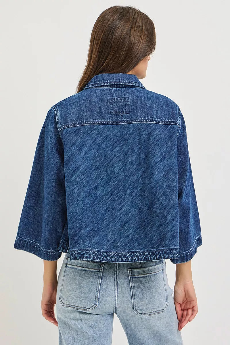 Back view: dark blue cropped double-breasted denim jacket with yoke and button detail