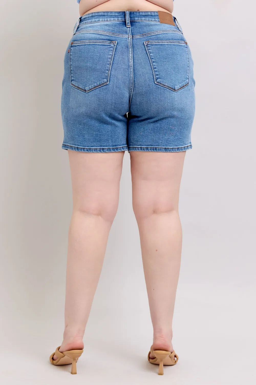 Medium wash denim shorts, back view with two back pockets and belt loops