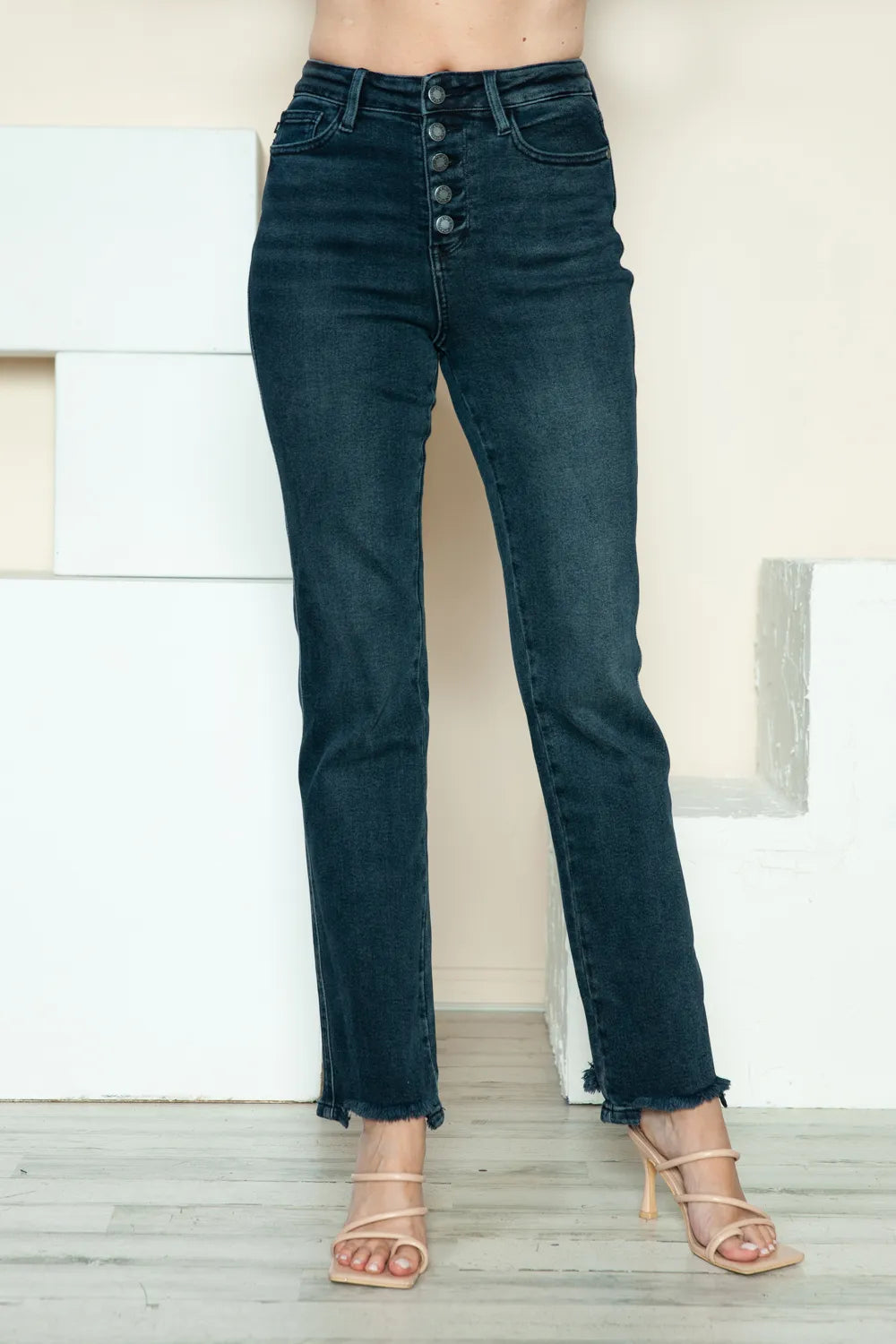 Dark blue straight jeans with button-fly, raw hem, and five-pocket styling
