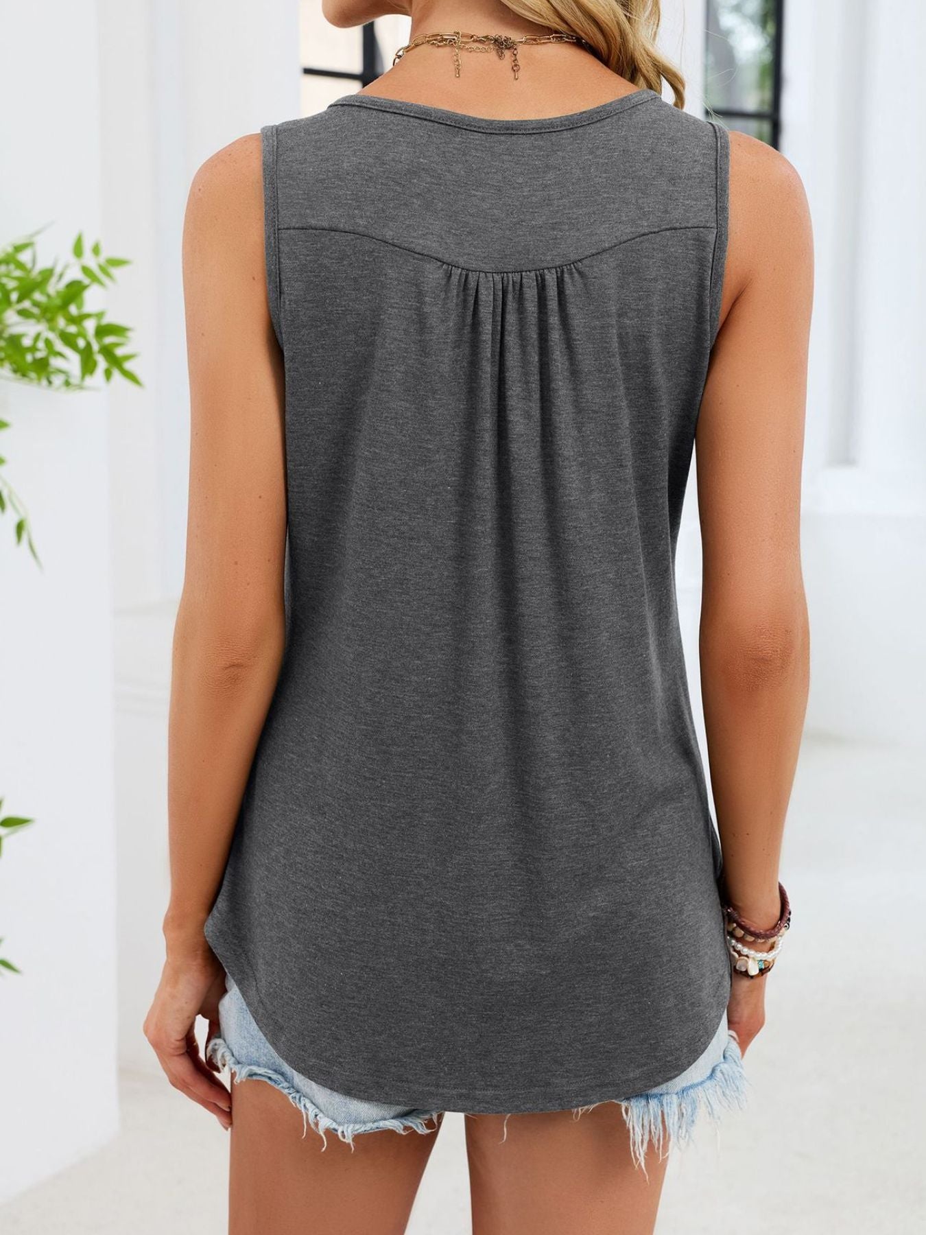 Back view button-detail round neck tank in gray, sleeveless with curved bottom hem