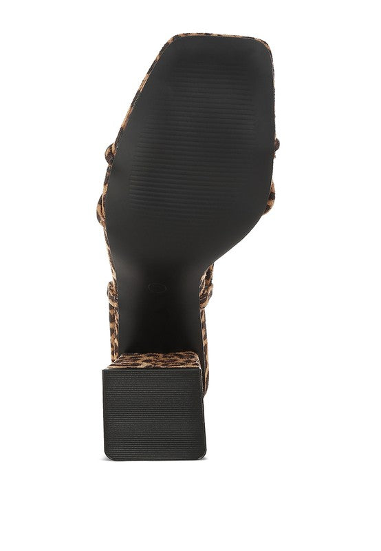 Black outsole view of leopard print square-toe heeled sandal with ankle straps