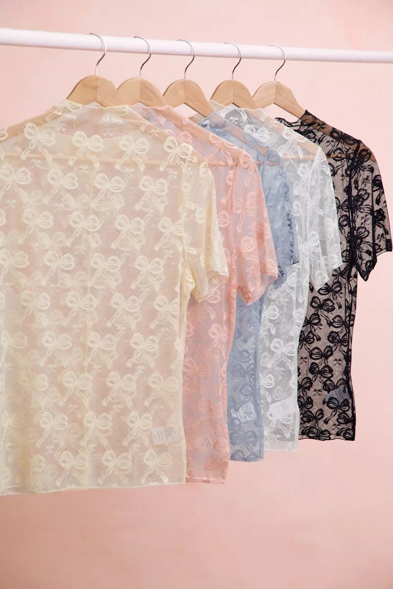 Set of sheer bow-pattern mesh tops on hangers