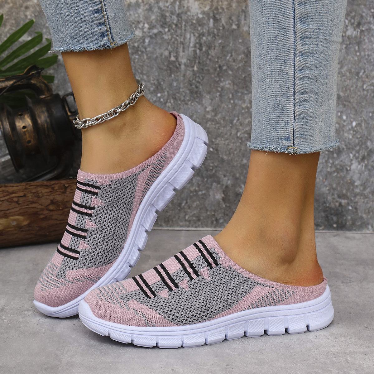 Pink breathable knit slip-on sneakers with black stripe motif and white sole