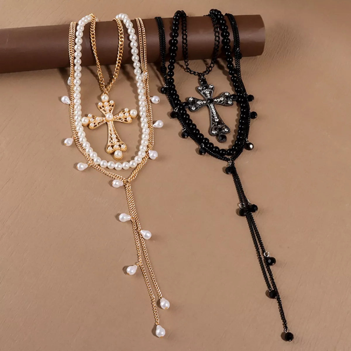 Pearl cross pendant necklace set with layered white pearls, gold-tone, and black bead chains
