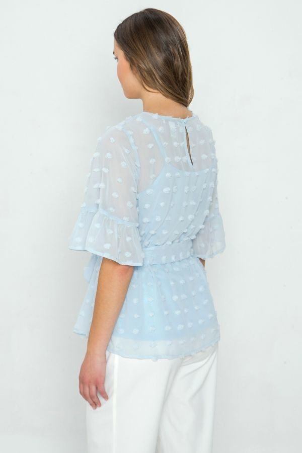 Light blue pom-pom top back view, dotted texture, tiered sleeves, keyhole opening