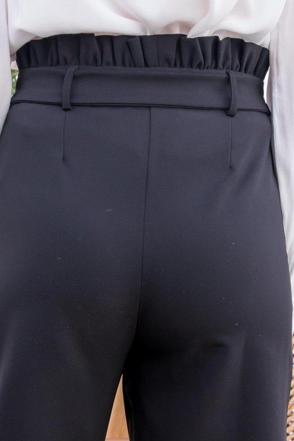 Black high-waist waistband close-up with ruffle and pleat details.