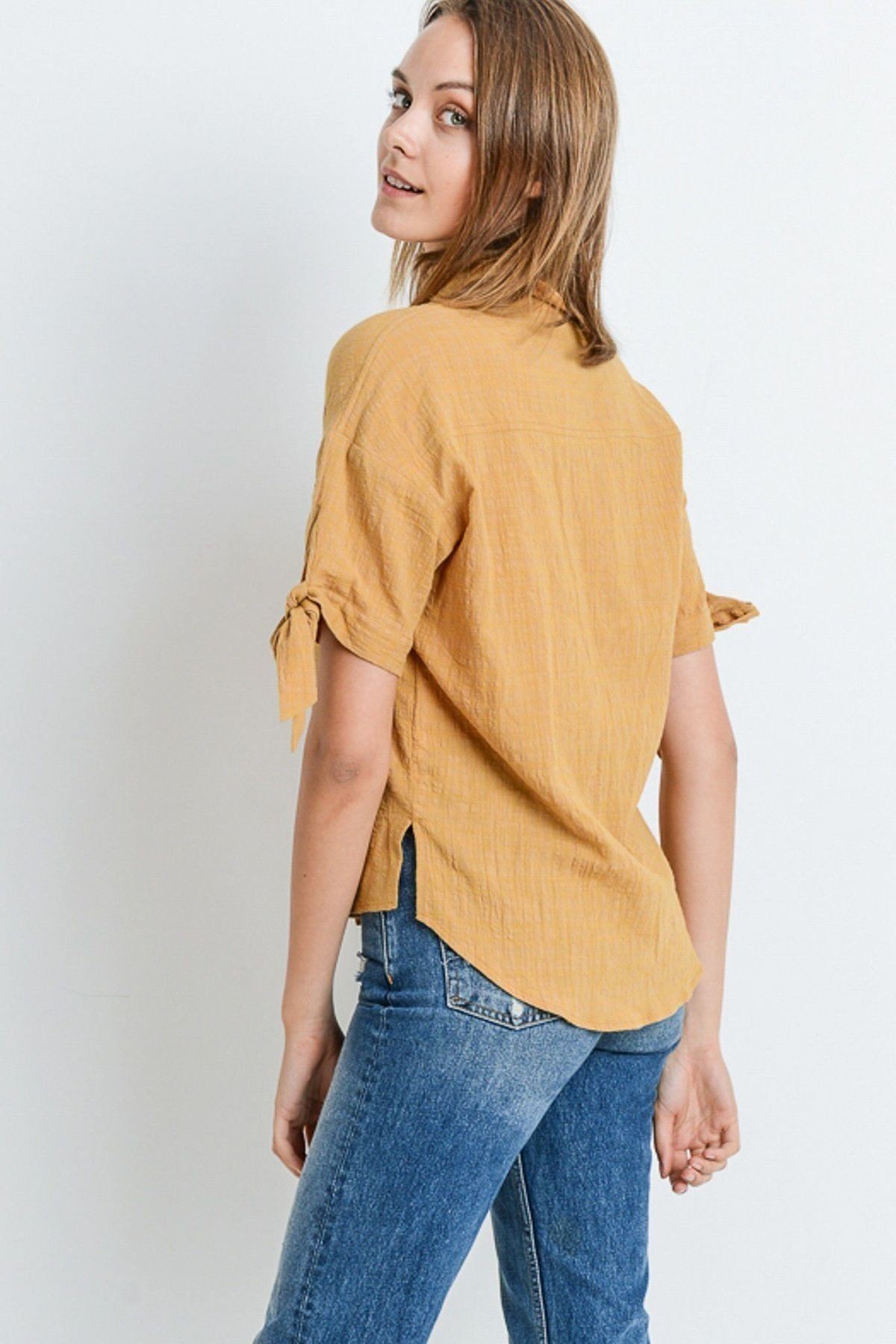 Back view short-sleeve button-up top with tied sleeves and curved hem