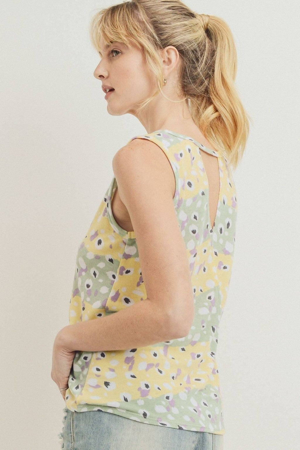 Printed sleeveless top, side view of yellow floral pattern and open neckline