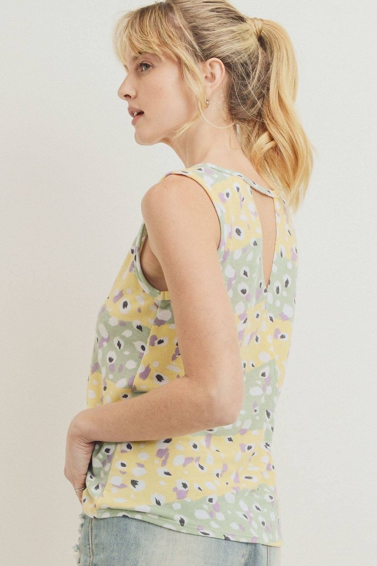 Printed sleeveless top, side view of yellow floral pattern and open neckline