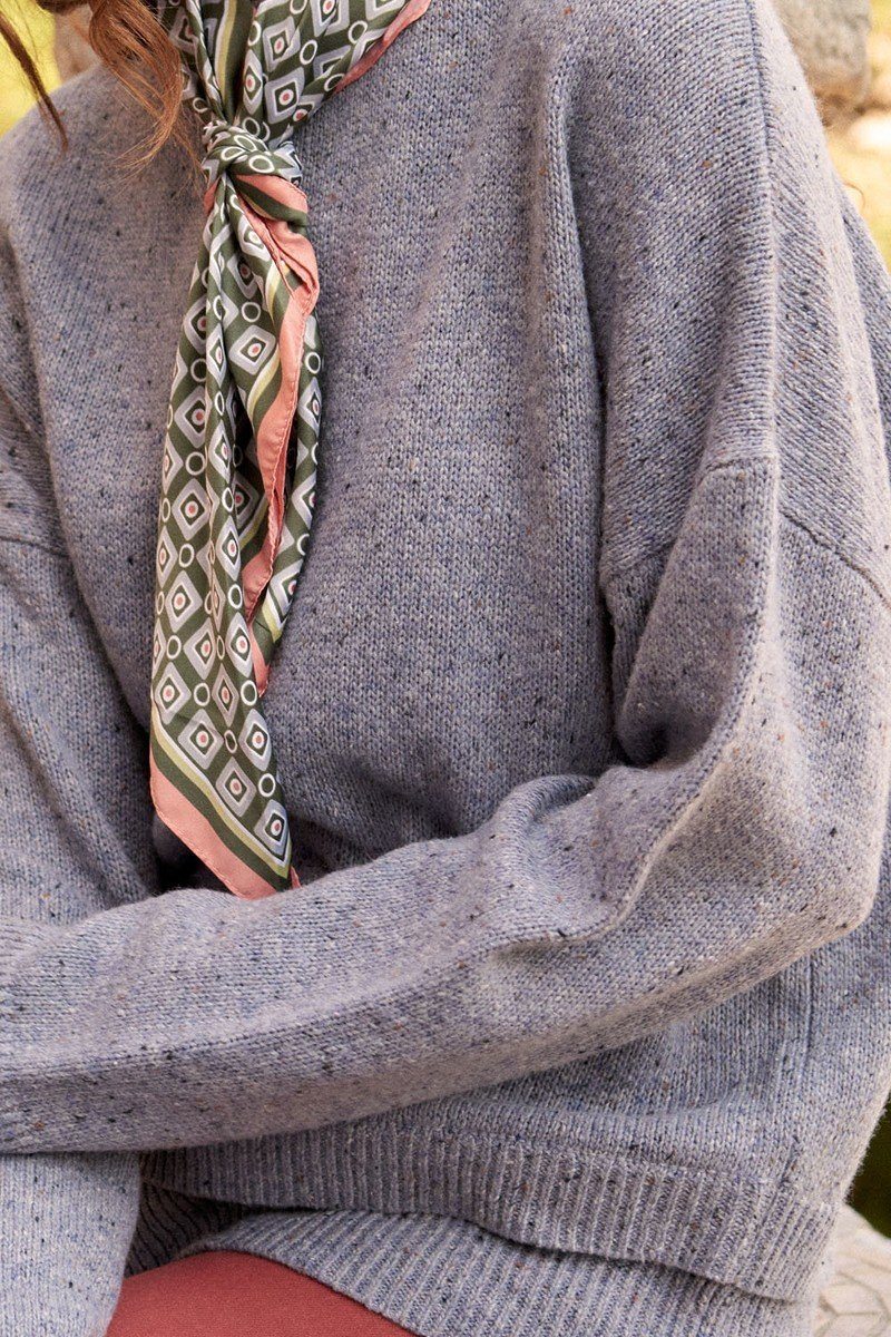 Grey speckled knit sweater close-up of sleeve and ribbed cuffs