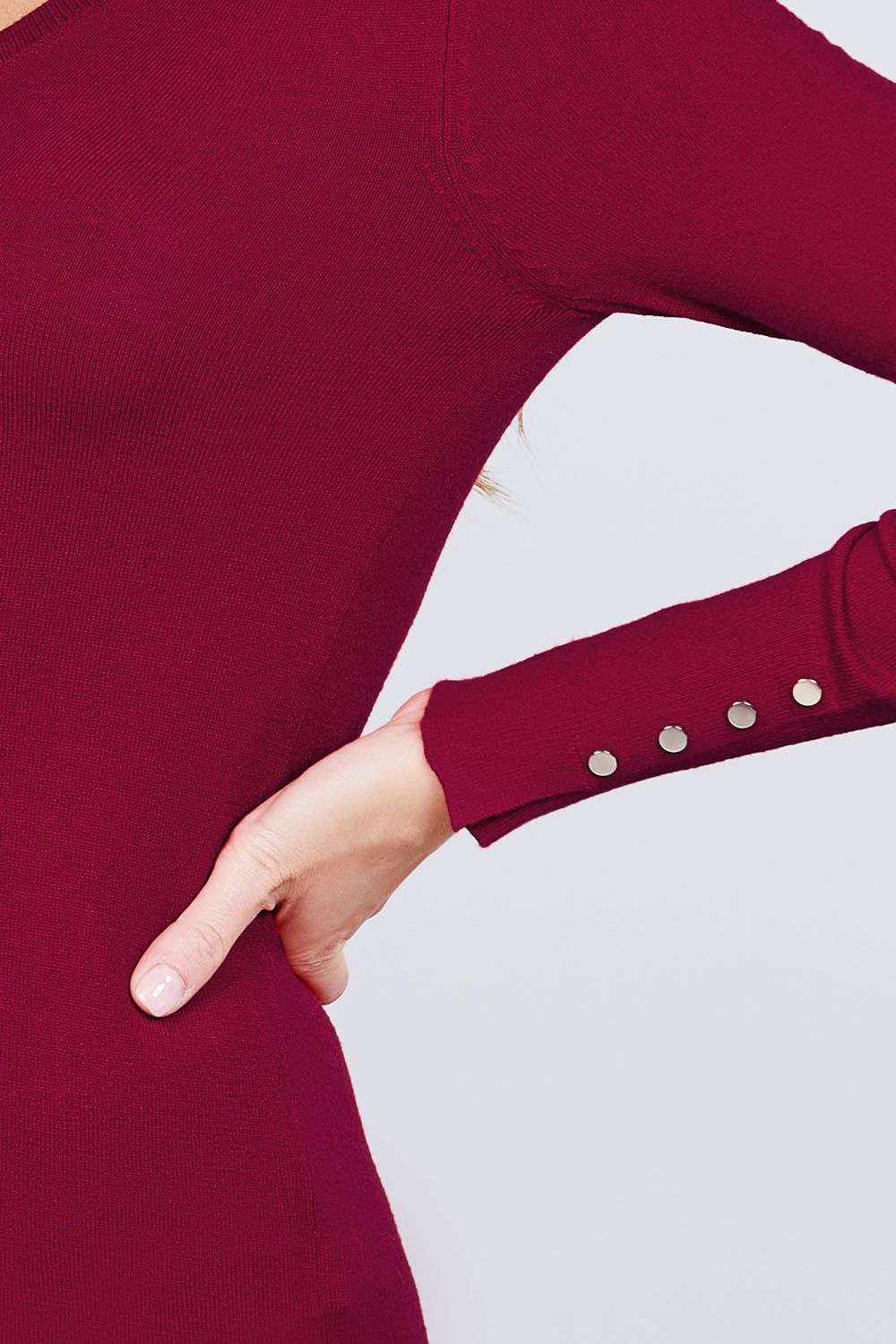 Close-up of rivet buttons on sweater cuff, bordeaux knit sleeve