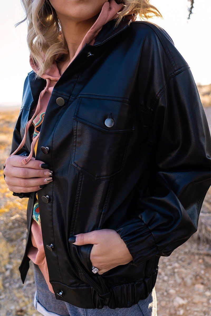 Dark faux leather jacket shoulder and pocket detail with snap buttons