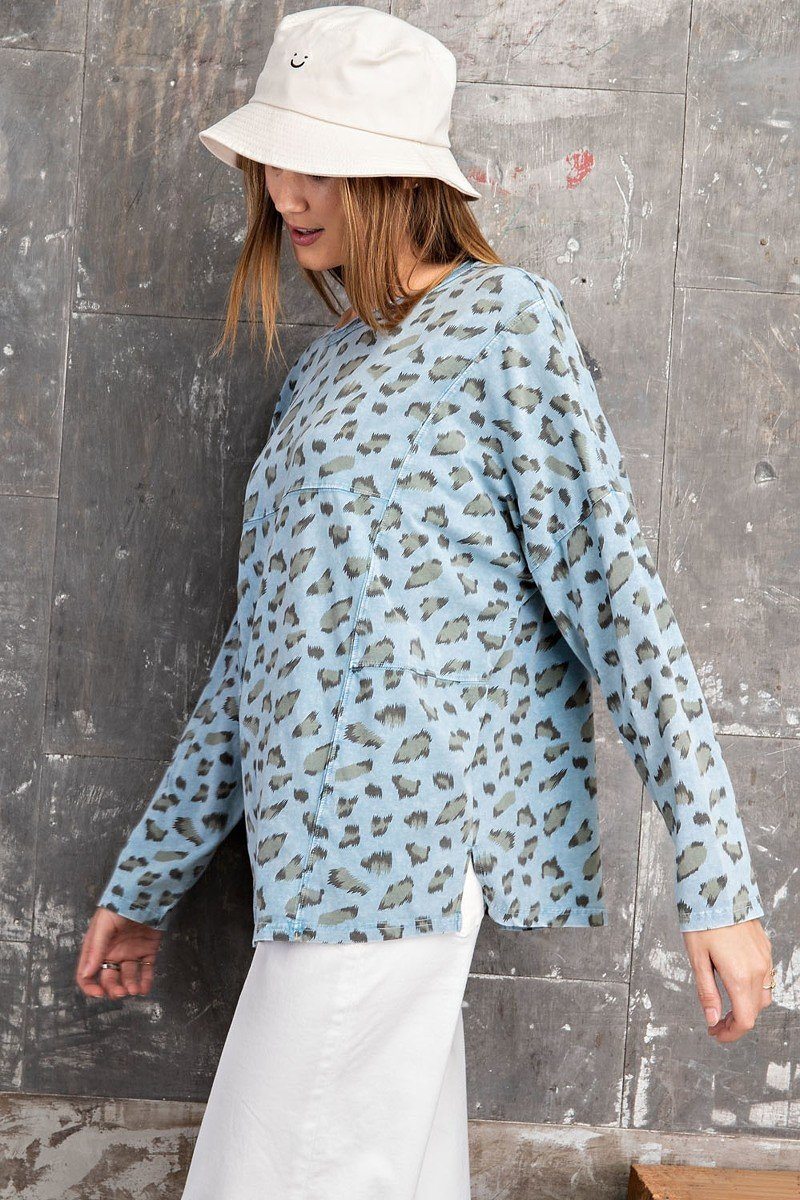 Leopard print loose knit top on model; light blue with dark spots, long sleeves