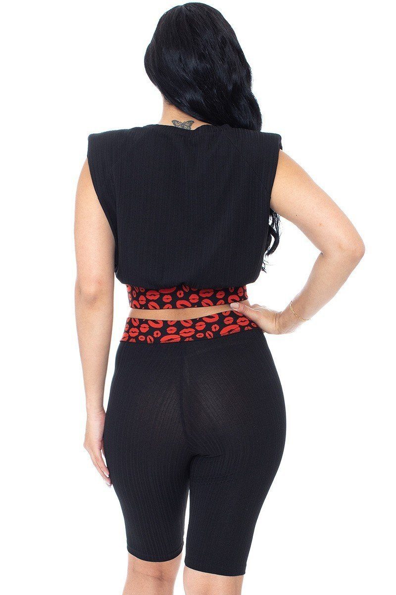 Vista trasera de shorts biker negros con banda roja estampada tipo leopardo