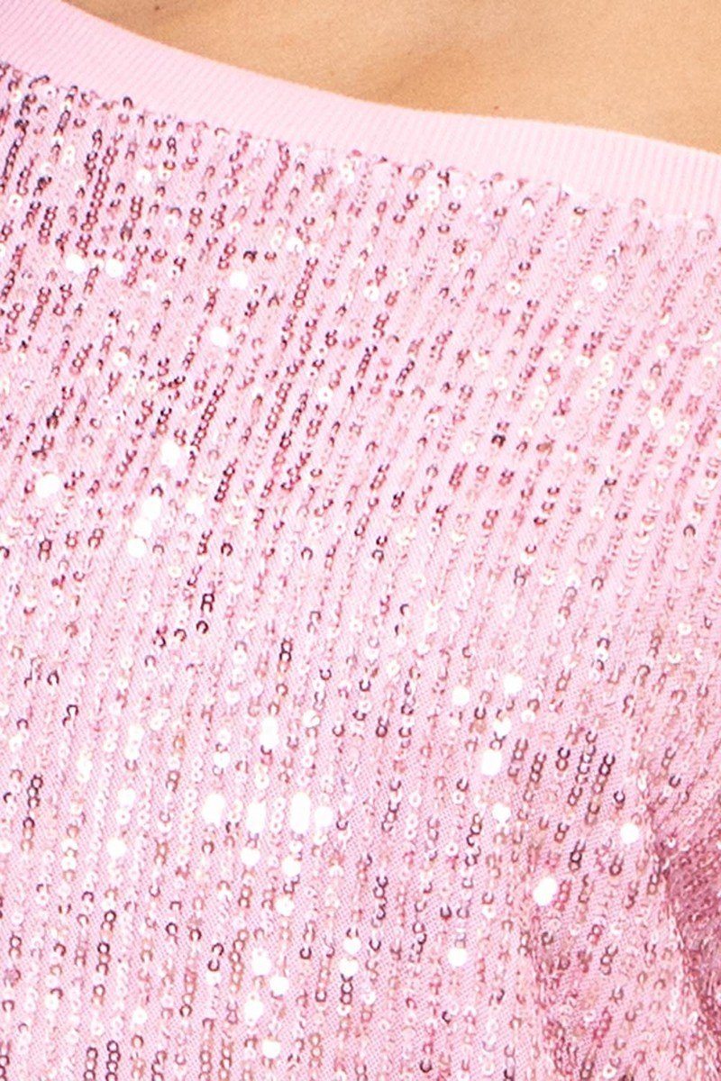 Dettaglio paillettes su abito rosa: superficie scintillante con base a maglia