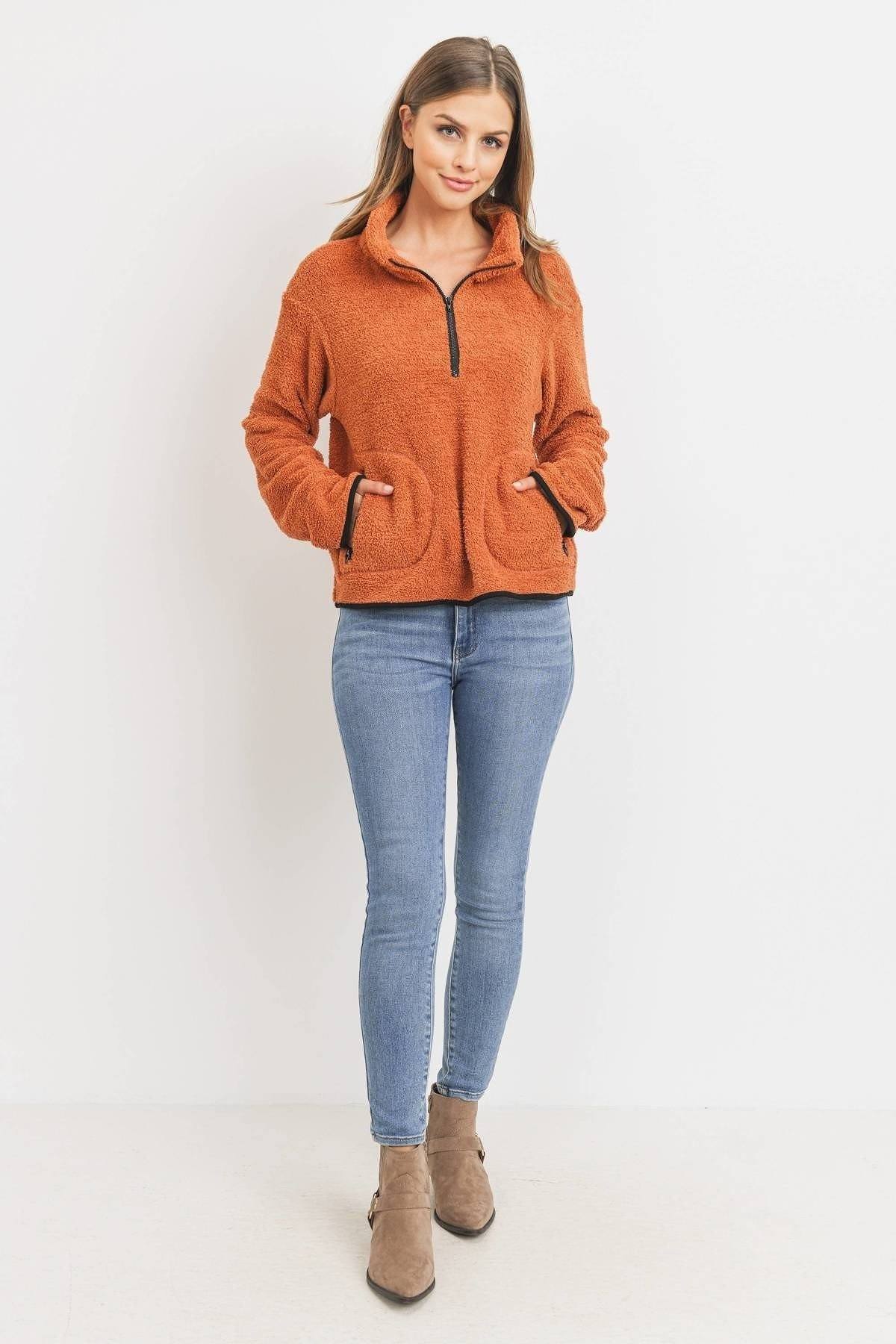 Long-sleeve half-zip pullover, orange fuzzy texture, worn with light blue jeans