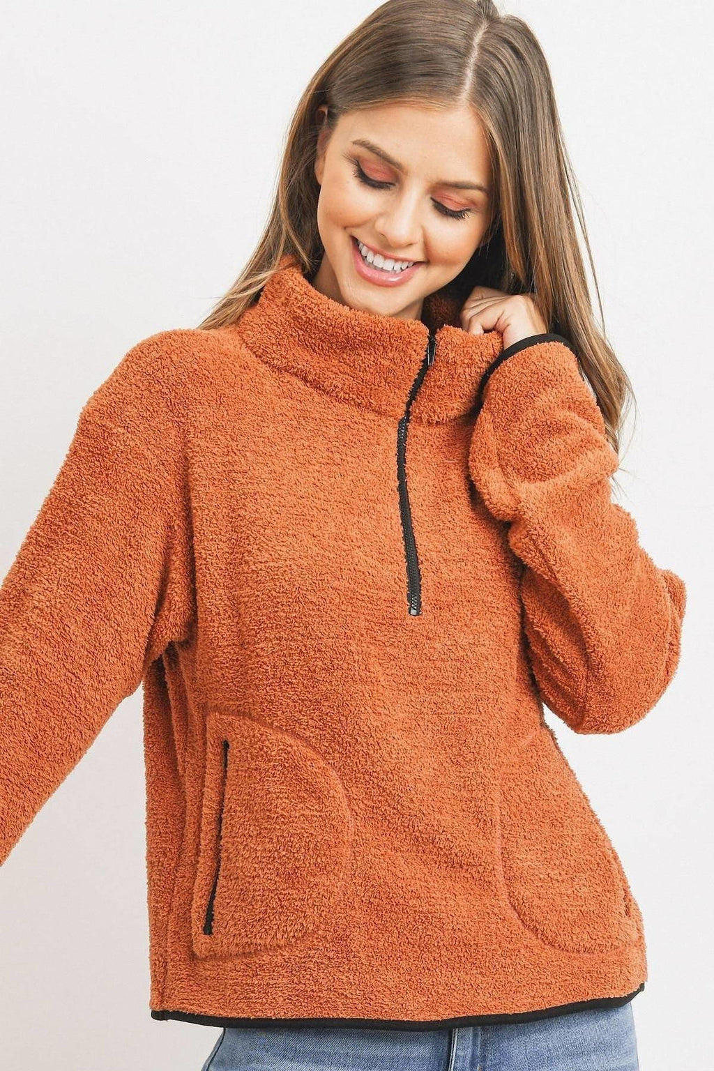 Orange half-zip pullover with drawstring-like zipper pull and two front pockets