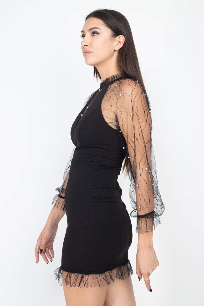 Black bodycon dress with pearl-studded sheer sleeves and halter neckline, side view