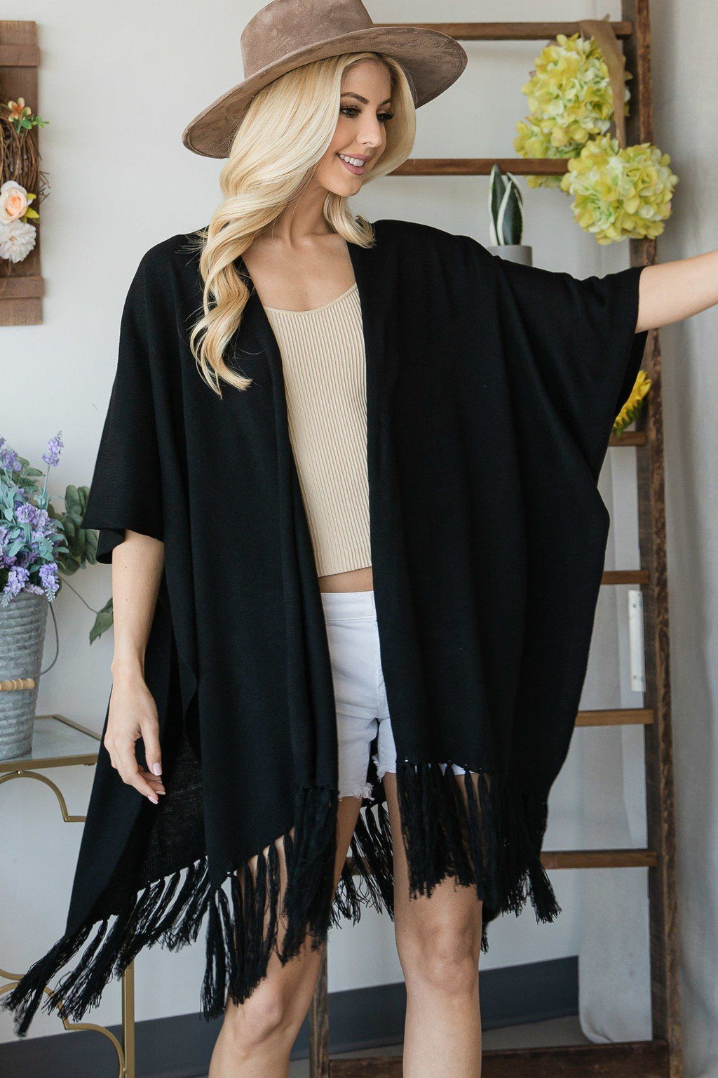 Black poncho cardigan draped at the sides with tassel-trim hem