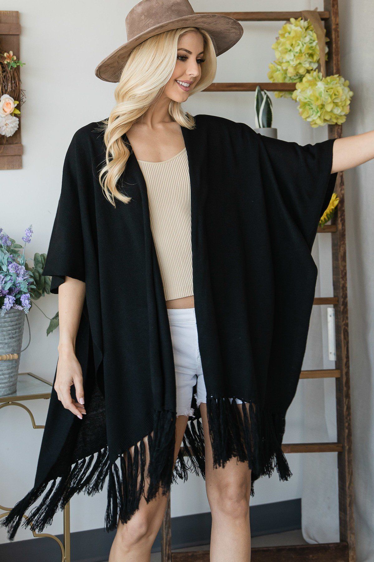Black poncho cardigan draped at the sides with tassel-trim hem