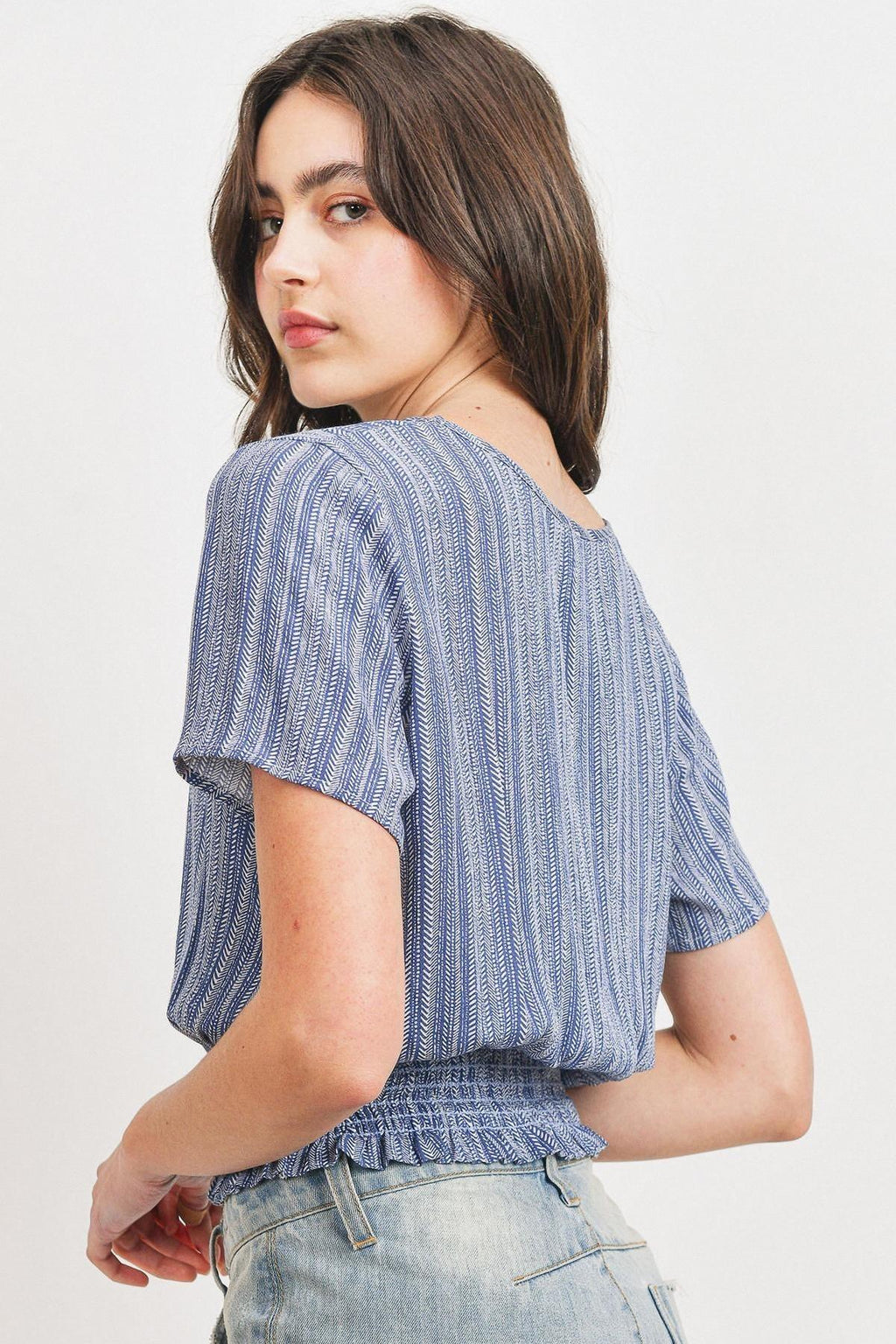 Back view of printed crinkle gauze top with smocked waist and short sleeves, blue