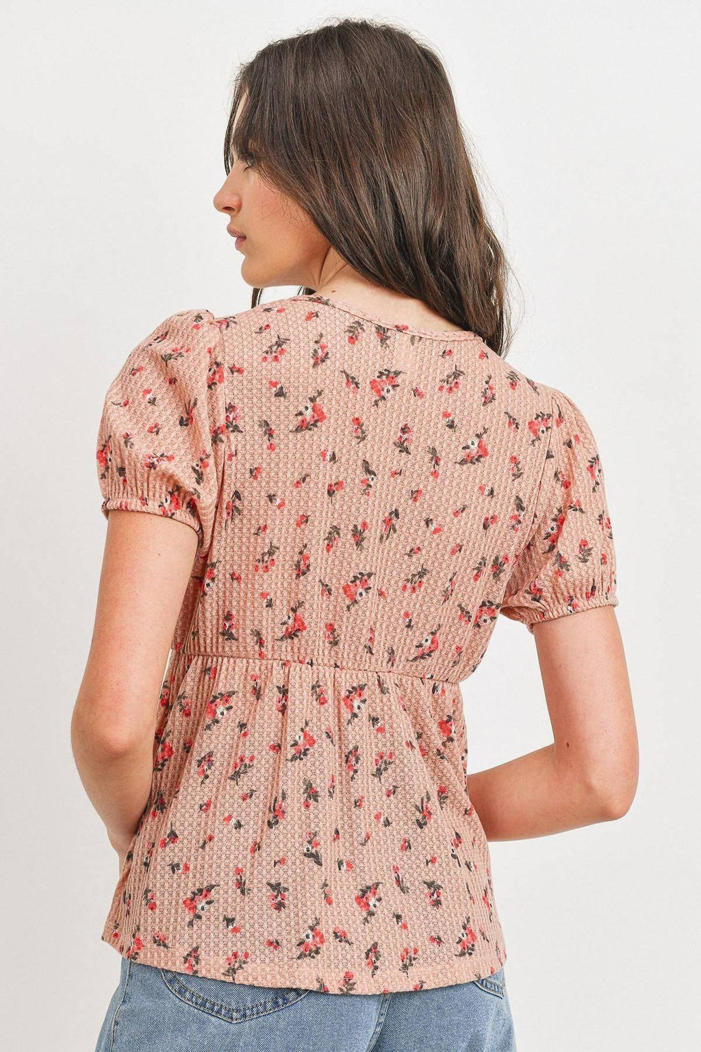 Back view of blush multi floral waffle top with puff sleeves and gathered waist