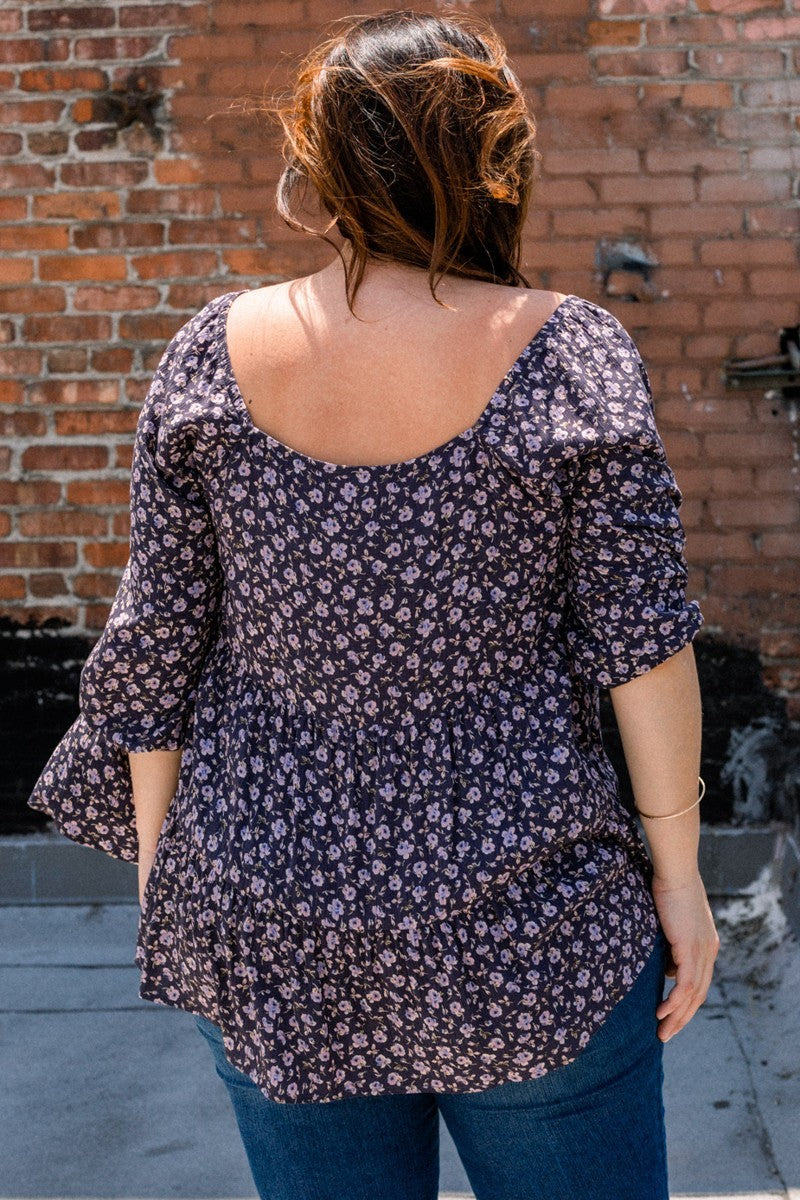 Back of navy floral square-neck top with gathered yoke and 3/4 sleeves