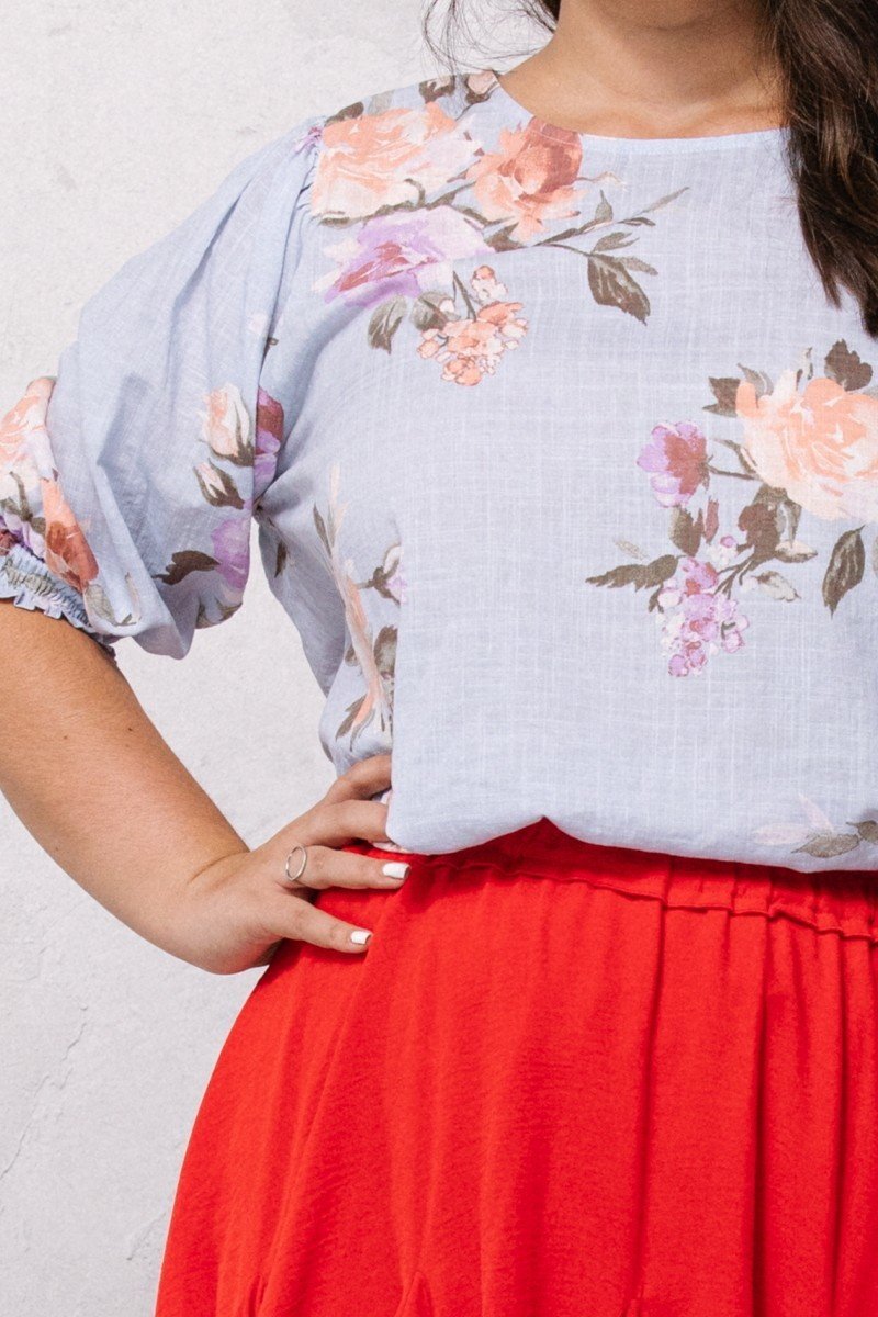 Spring blue floral blouse close-up: elastic puff sleeves and gathered cuffs