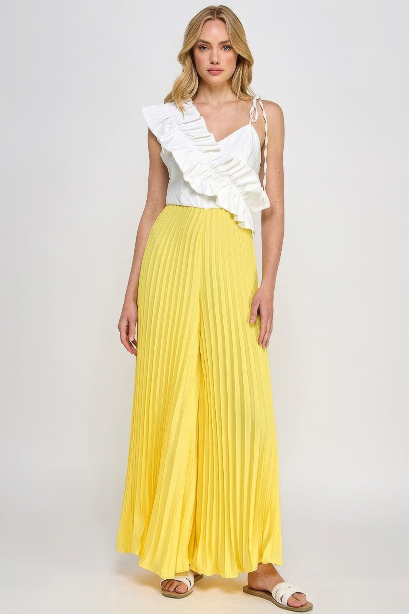 Cami jumpsuit with white asymmetrical ruffle bodice and yellow pleated wide-leg pants