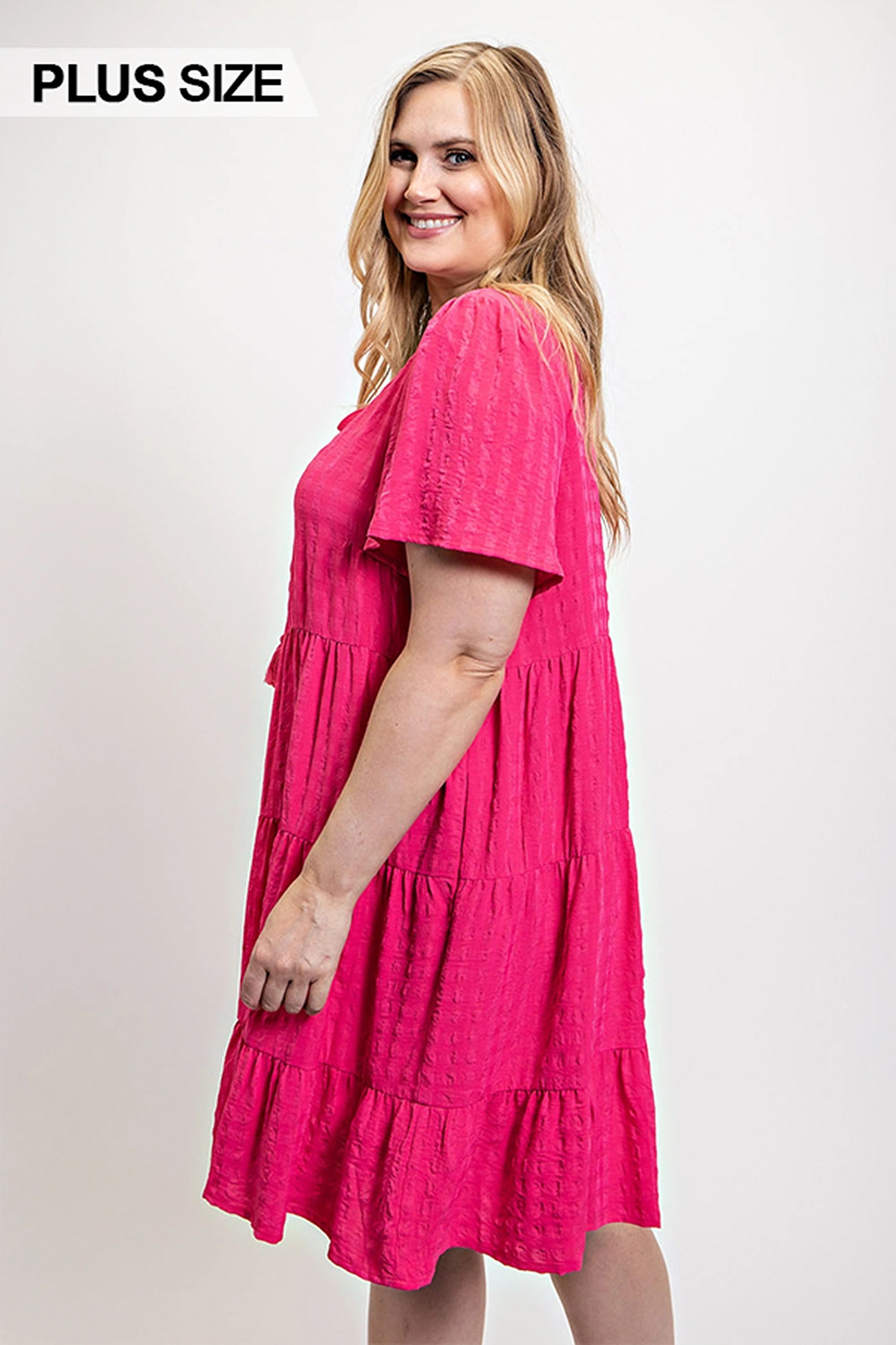 Textured fuchsia tiered dress with short sleeves, side back view