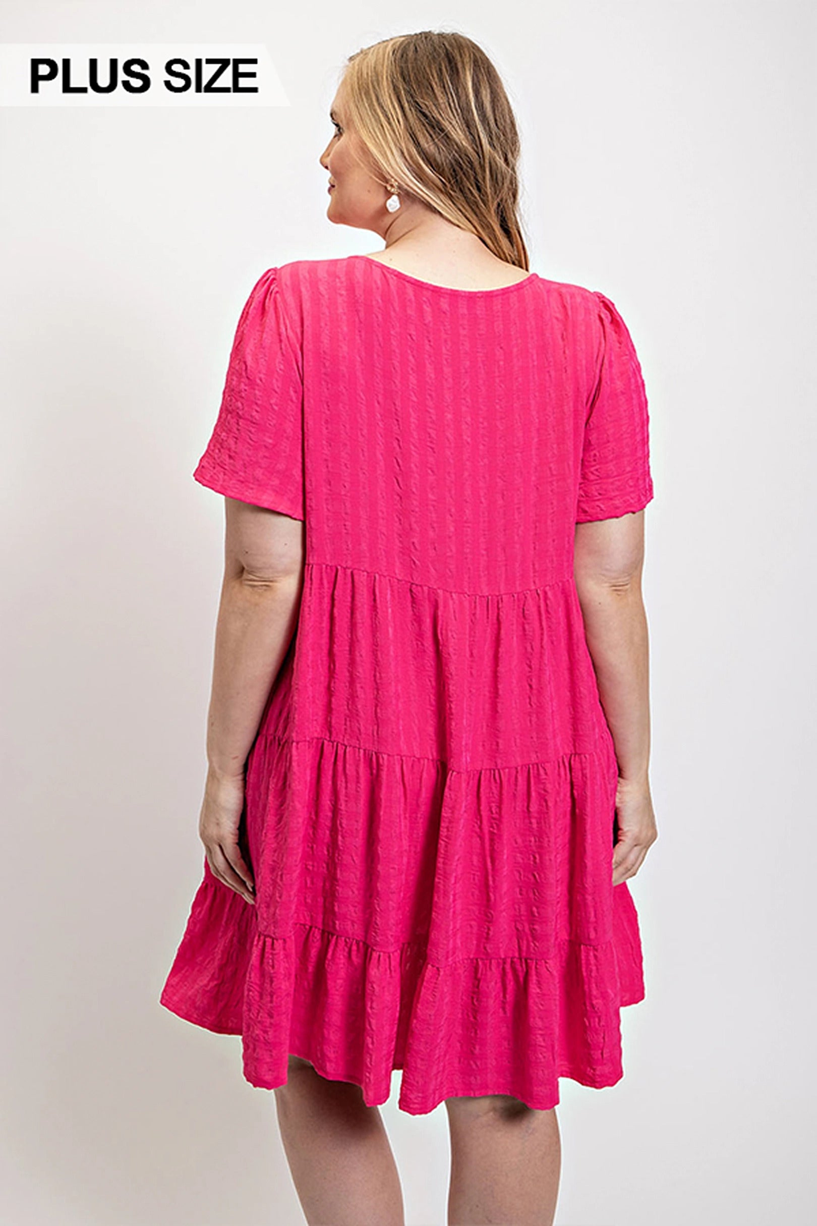 Back view of textured fuchsia tiered dress with tiered skirt and short sleeves