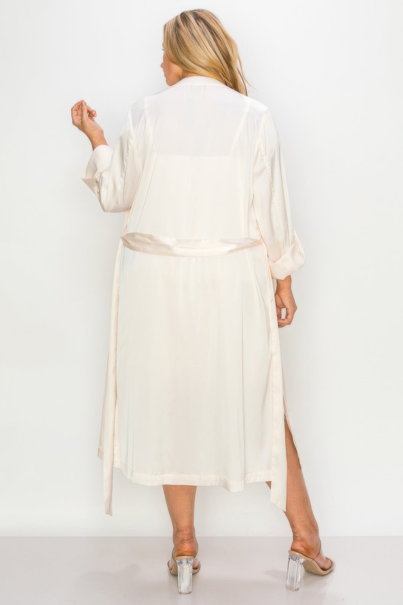 Back view of cream satin strap dress with self belt and long matching coat