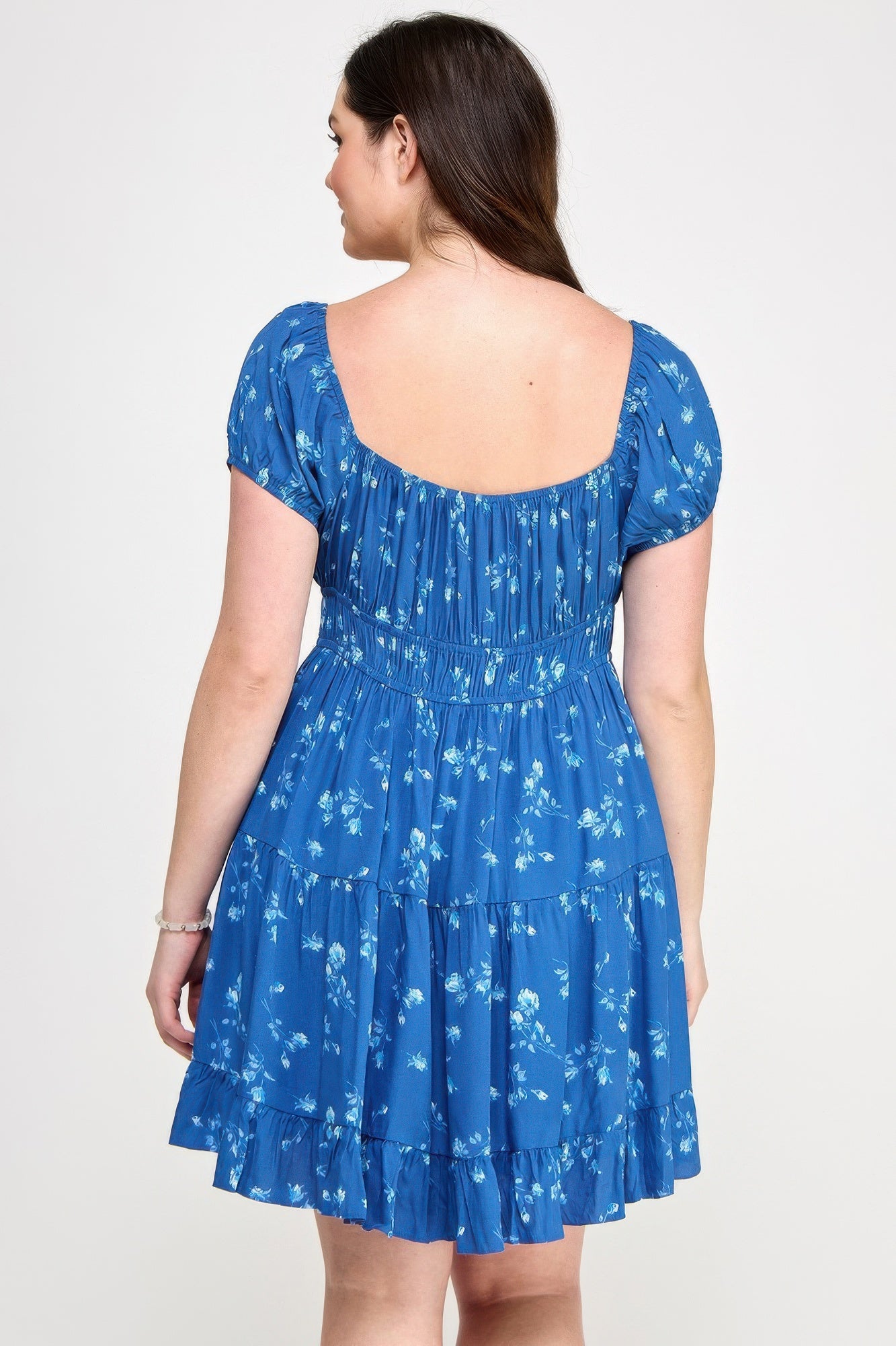 Back view of blue floral ruffle mini dress with elastic waist and short puff sleeves