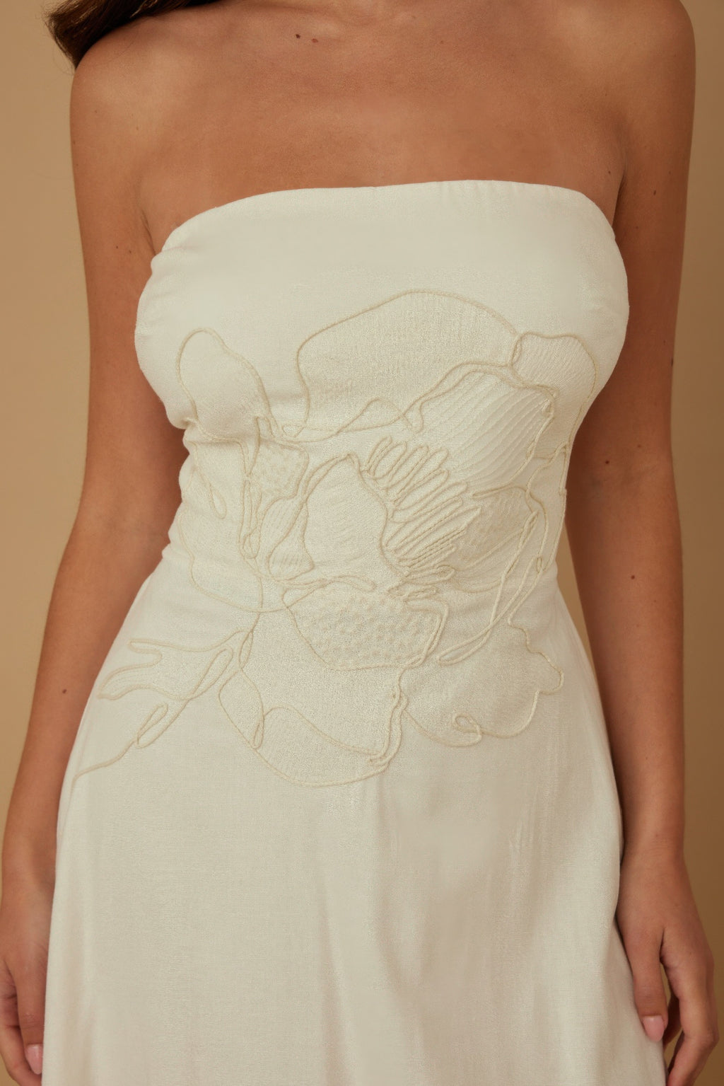 Close-up: ivory strapless linen bodice with floral embroidery and gathered texture