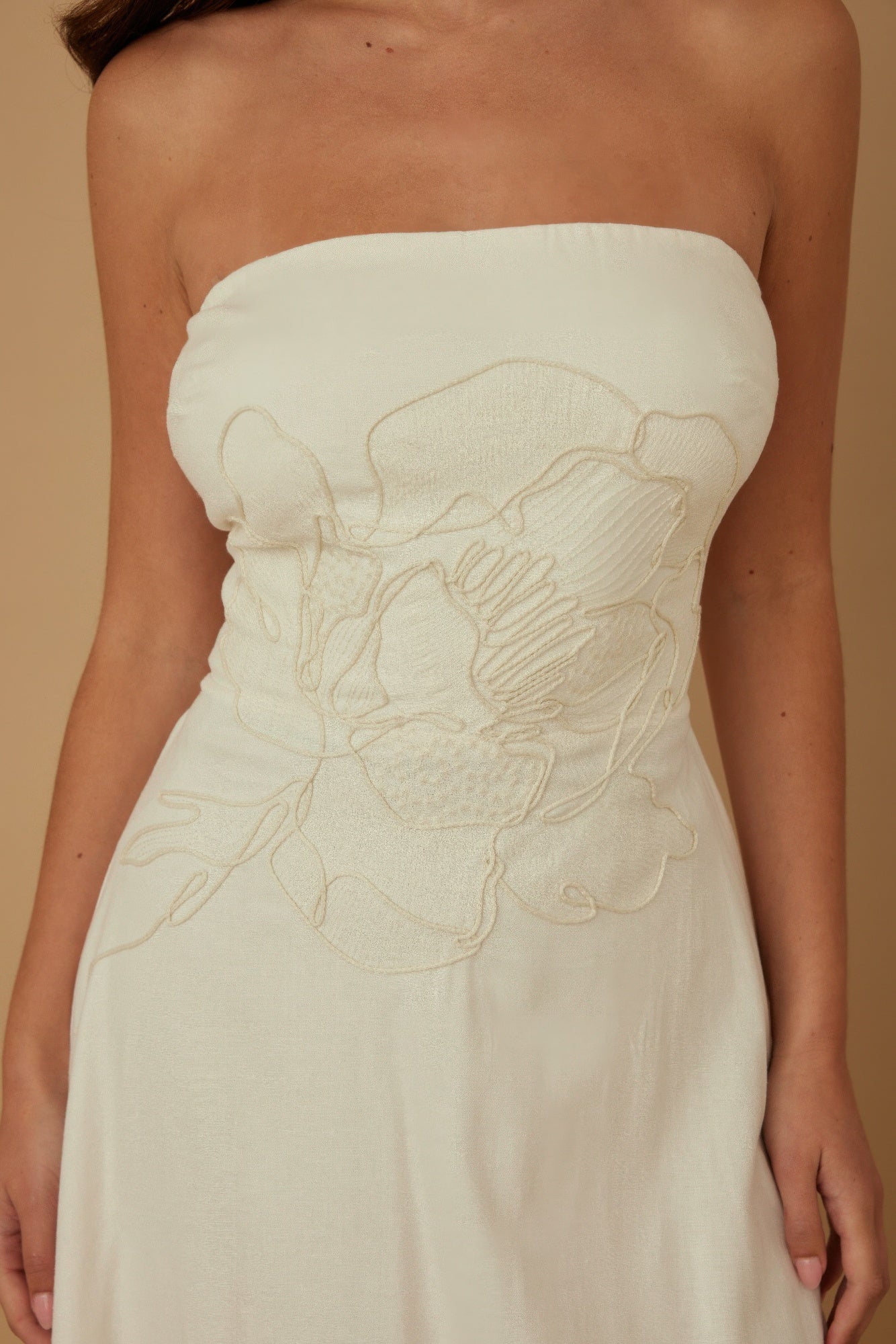 Close-up: ivory strapless linen bodice with floral embroidery and gathered texture