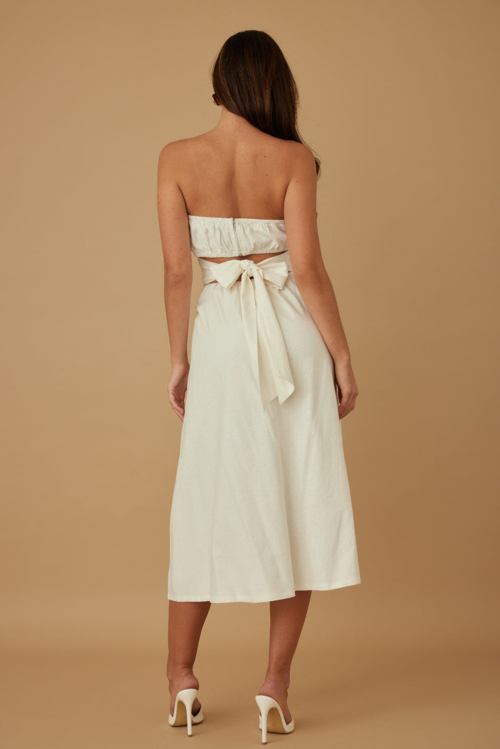 Rear view: ivory strapless linen midi dress with bow at the back waist