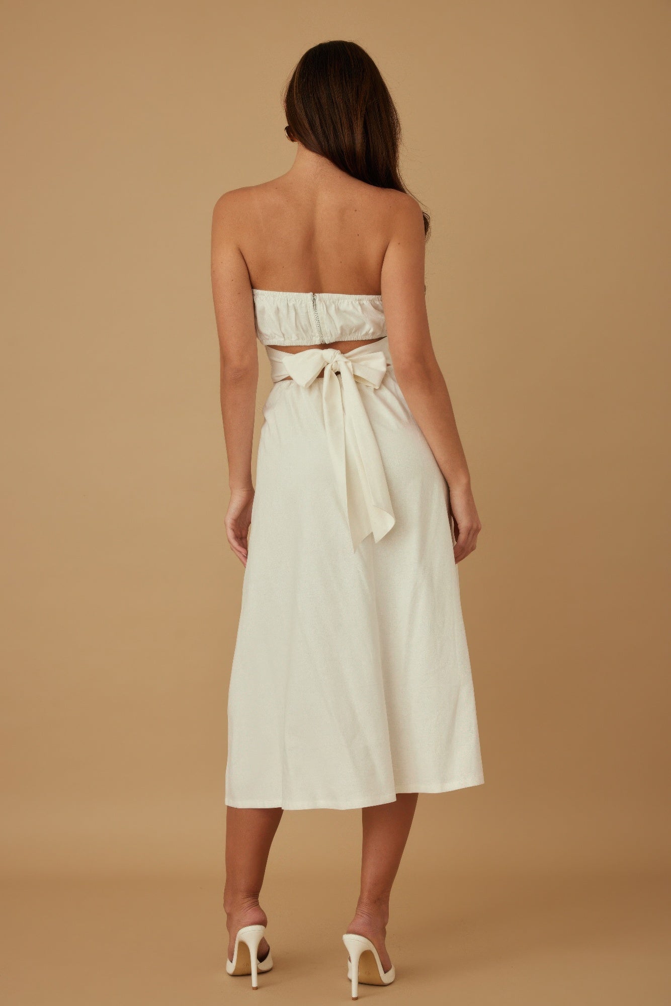 Rear view: ivory strapless linen midi dress with bow at the back waist