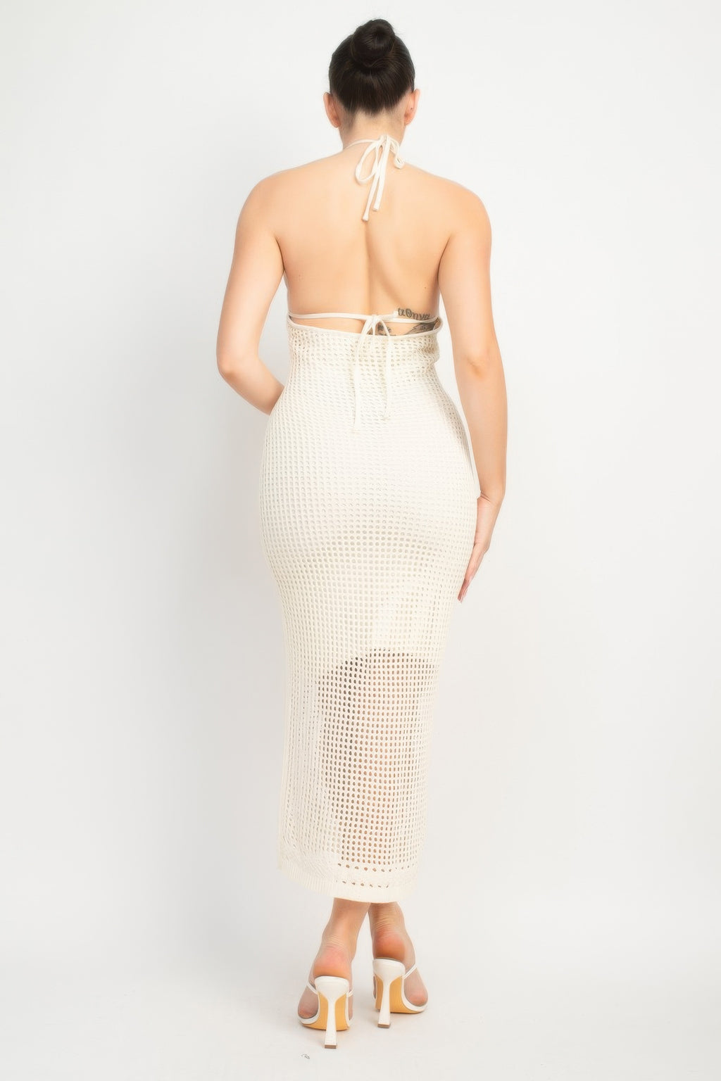Cream open-back midi dress from the back, halter tie detail and fitted knit mesh