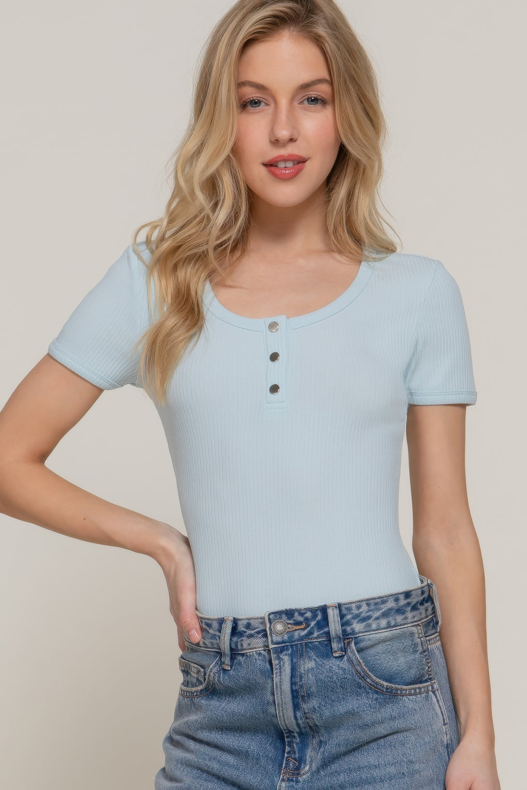 Pale blue ribbed knit bodysuit front view with snap buttons at neckline