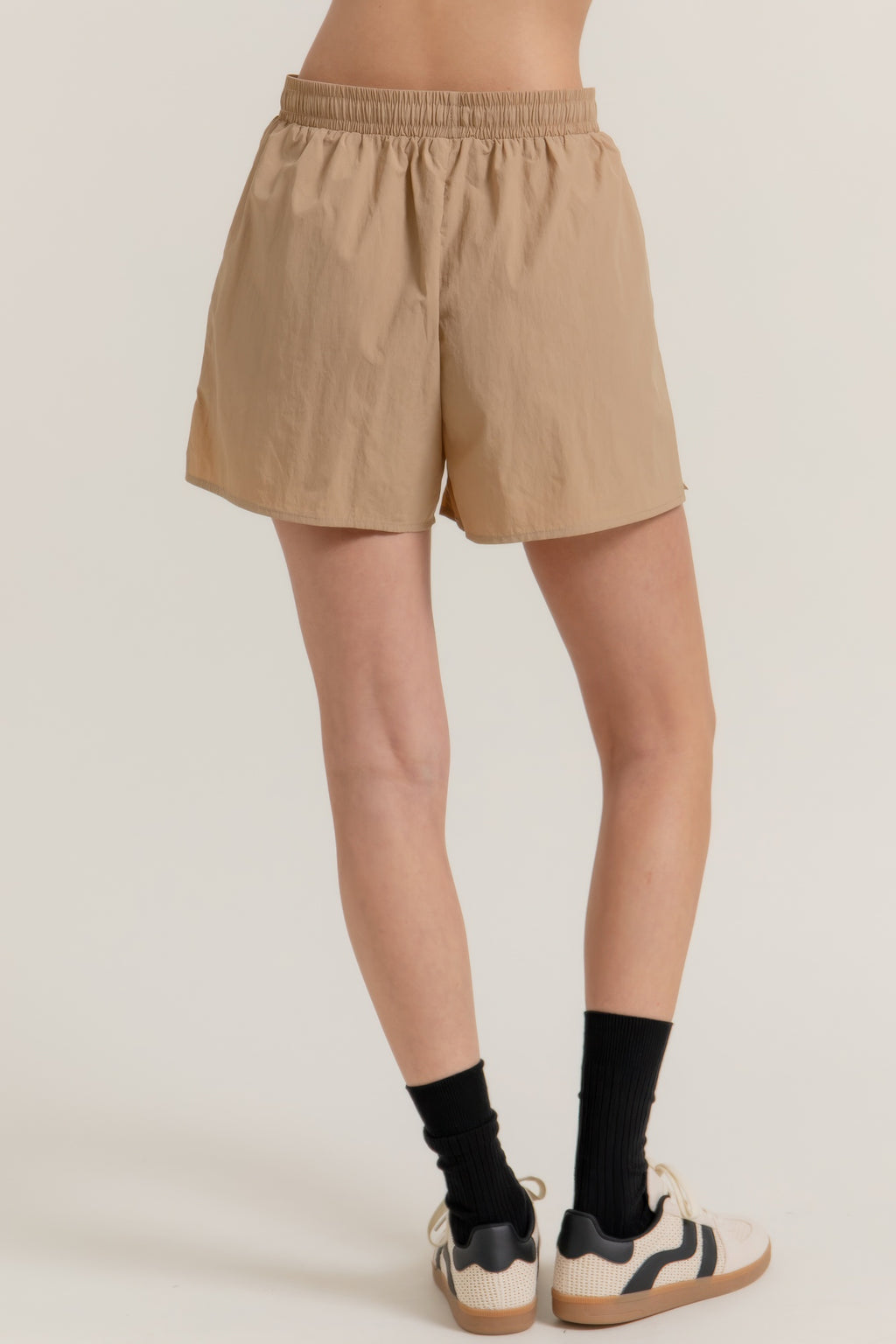Khaki workout shorts with elastic waistband, relaxed fit, side slit hem