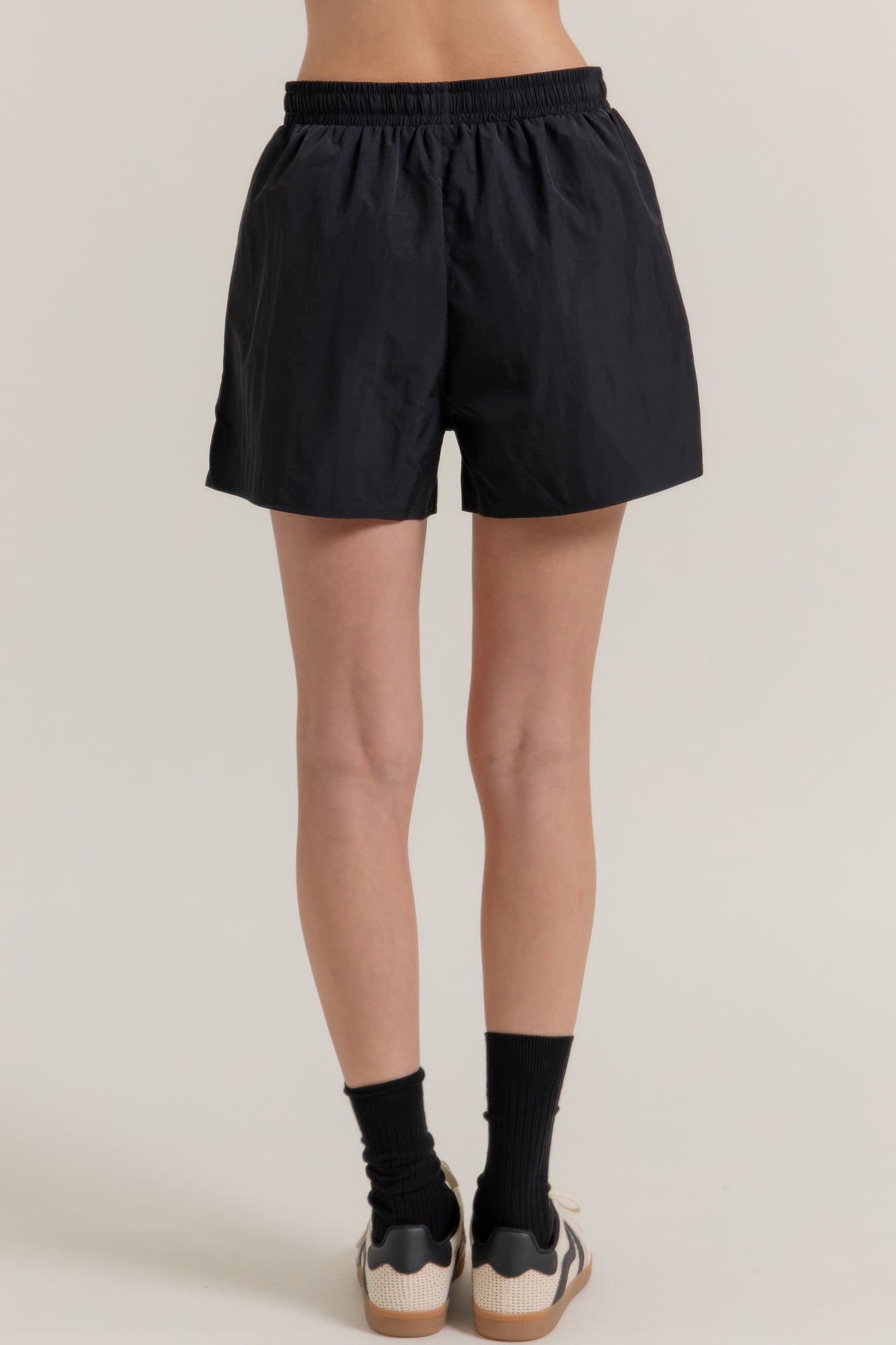 Black workout shorts with elastic waistband and straight side hem, mid-thigh length