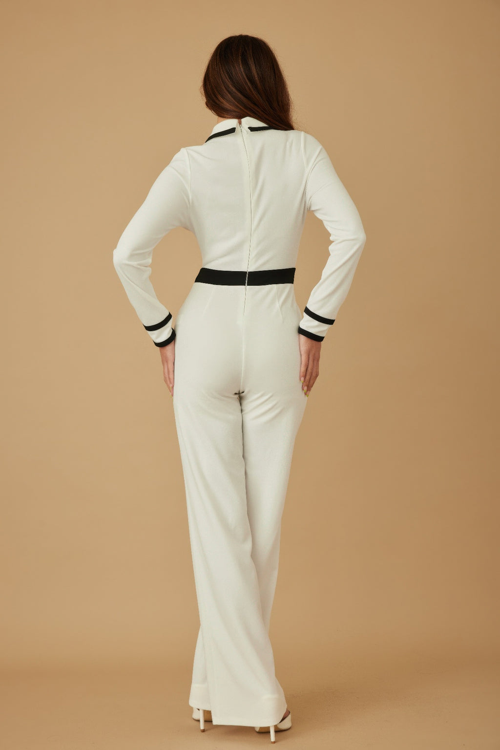 Cream-white back view of jumpsuit with black waistband and striped cuffs