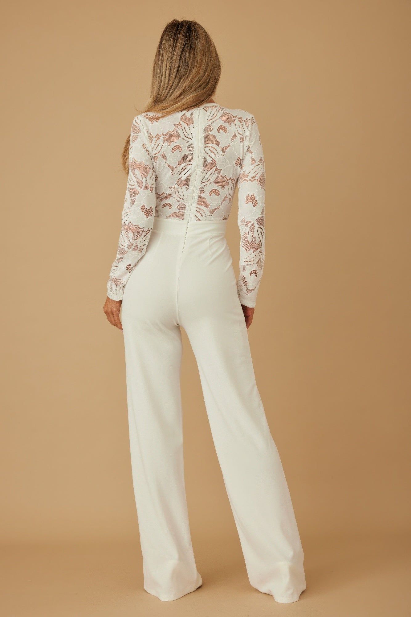Back view: white lace crochet long-sleeve jumpsuit with center seam and wide legs